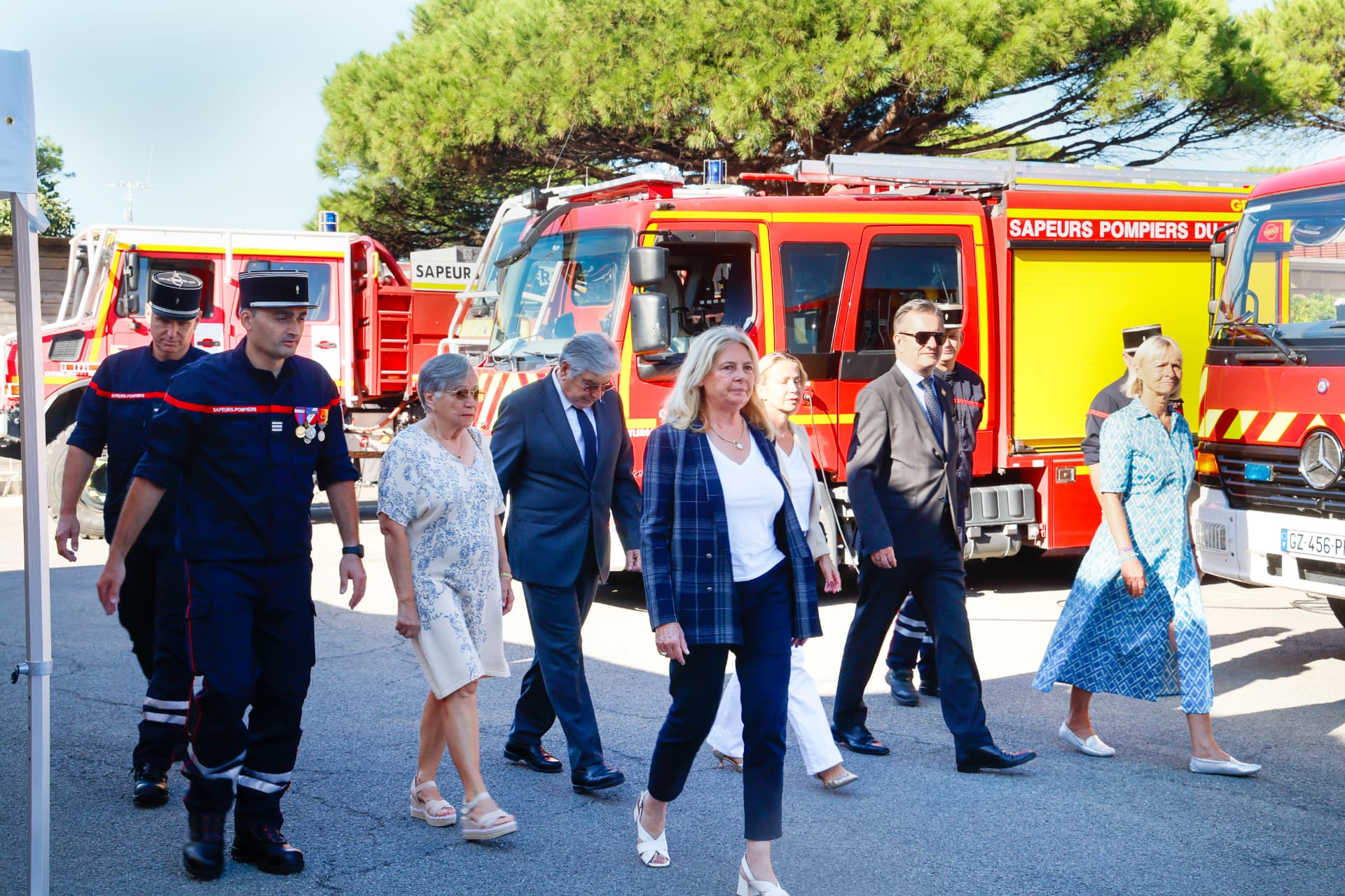 Cérémonie officielle en extérieur avec sapeurs-pompiers et véhicules de secours