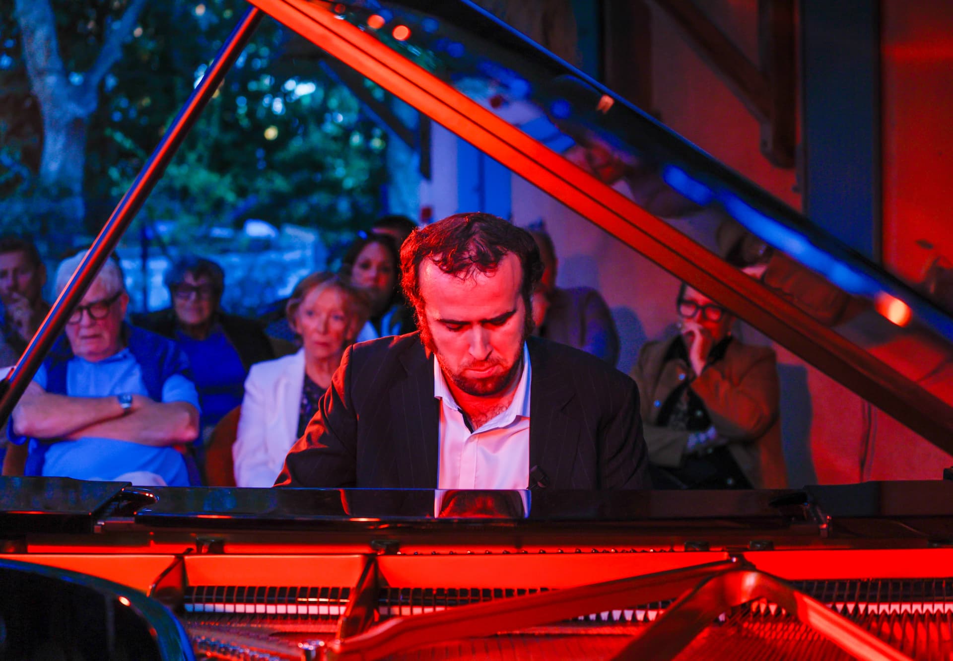 Pianiste en concert sous une lumière contrastée face au public