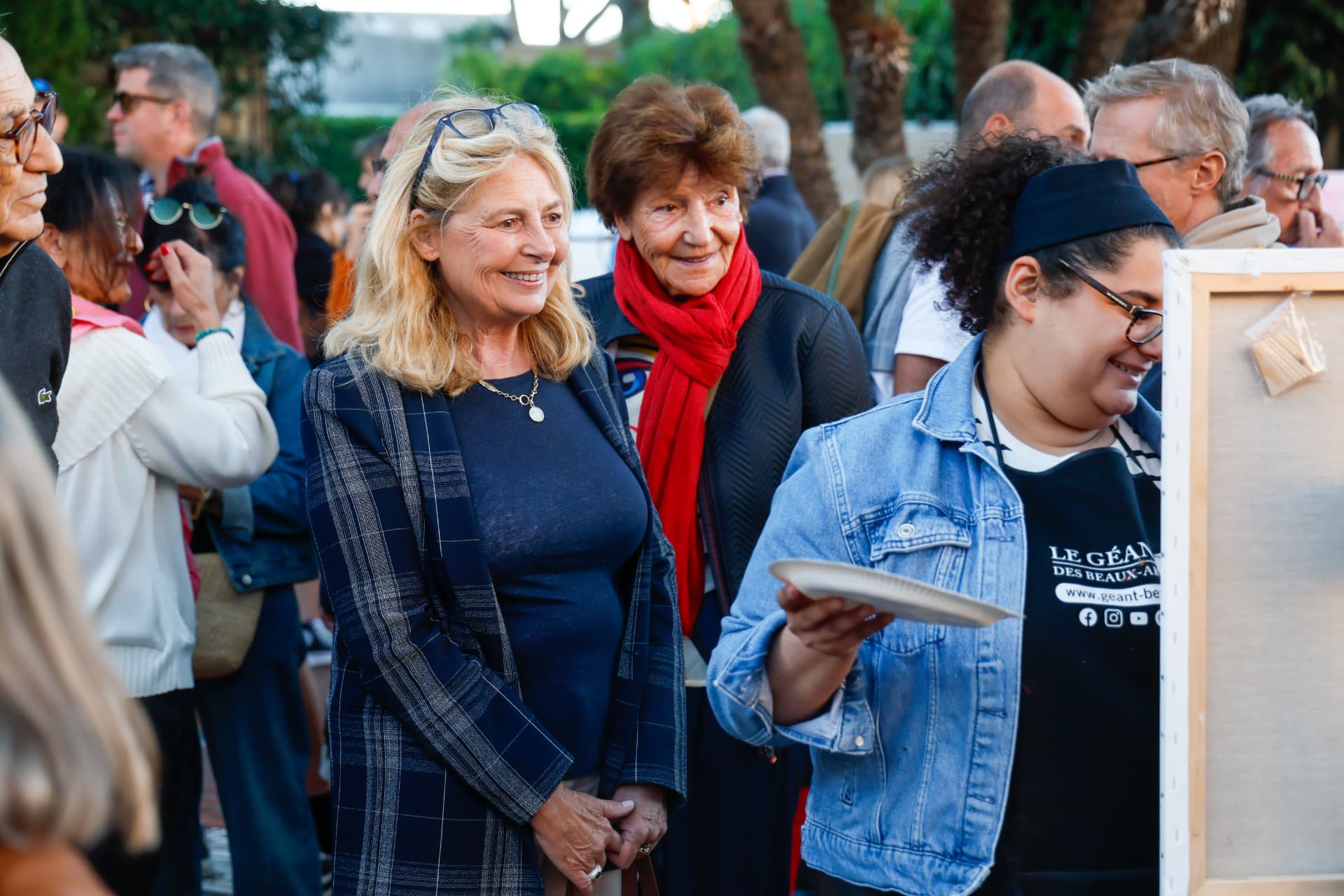 Public rassemblé autour d'un stand lors d'un événement culturel en plein air
