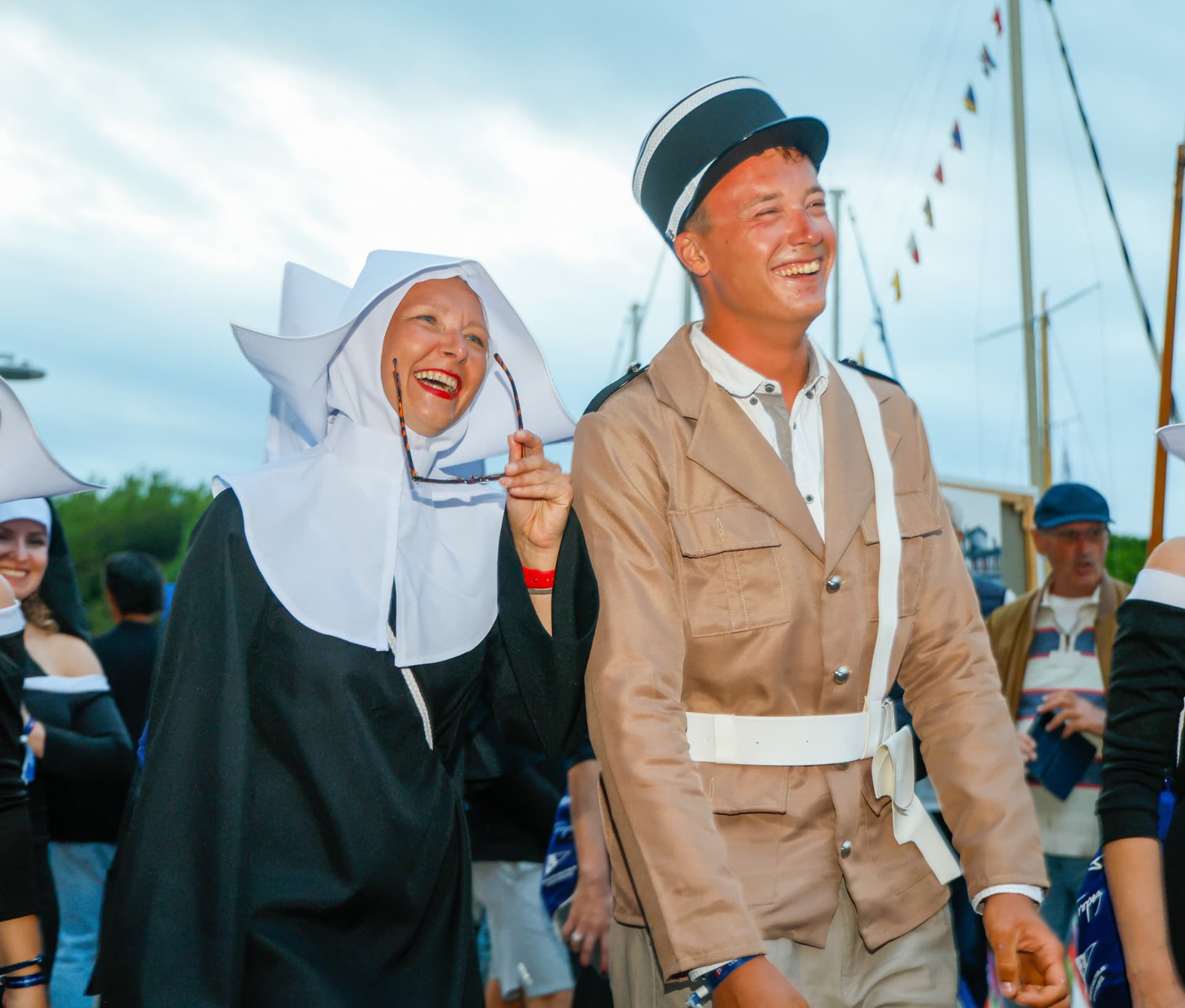 Participants costumés souriants lors d'une fête maritime