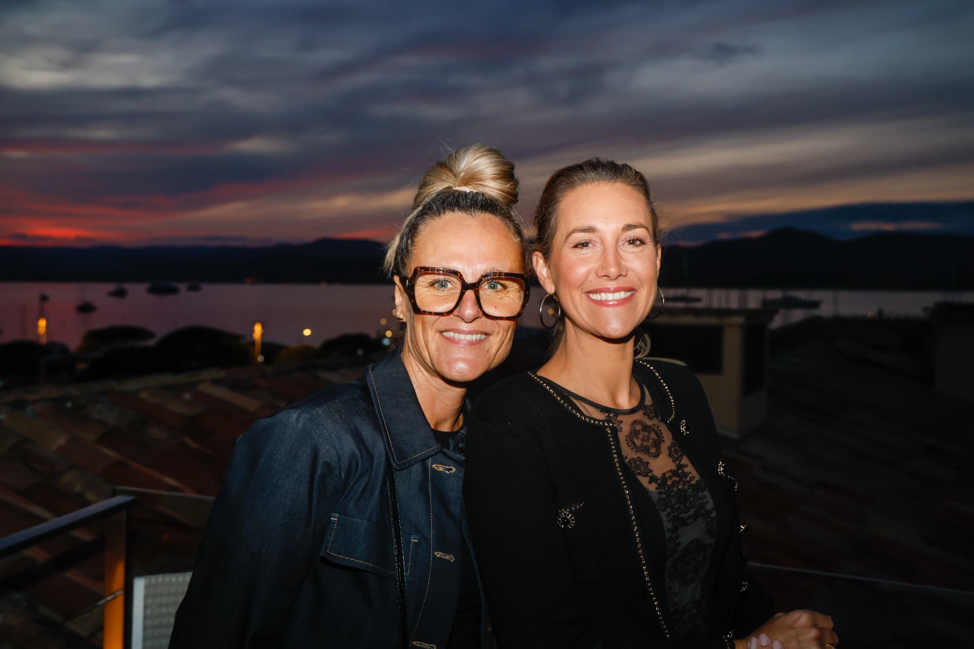 Deux femmes souriantes au coucher du soleil au-dessus du port