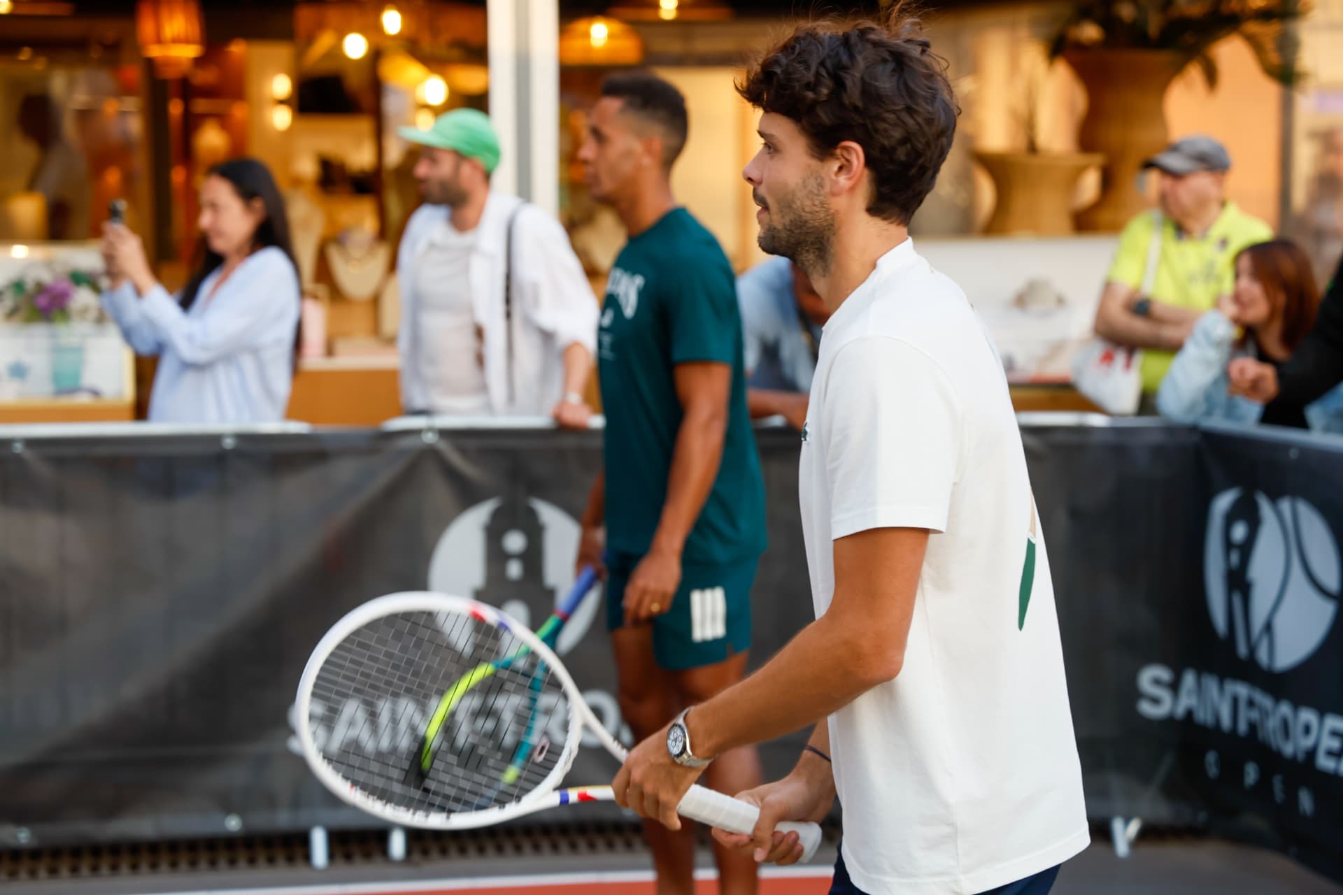 Joueur au service lors d'un tournoi de tennis devant le public