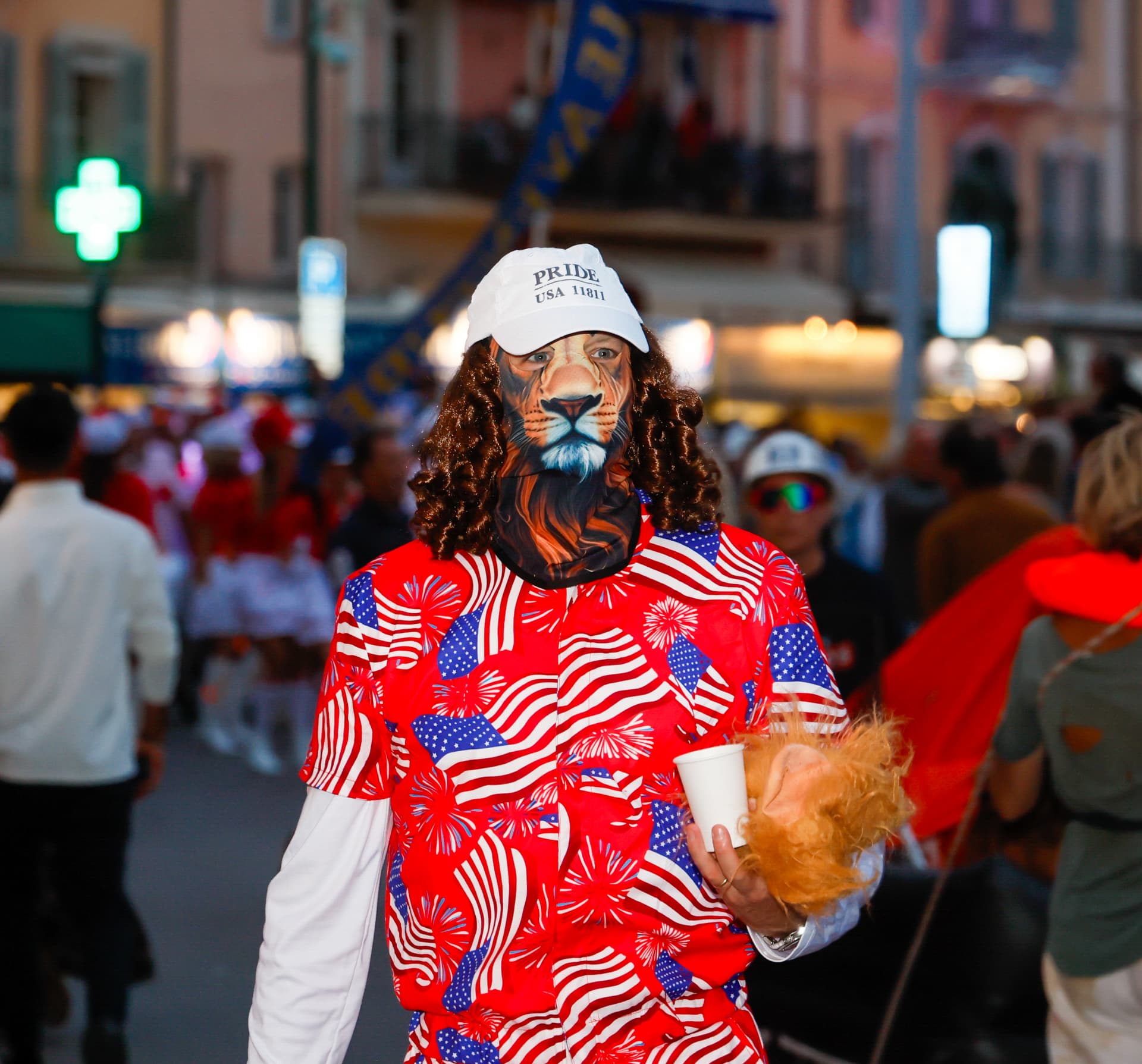 Participant en costume coloré et masque de lion au milieu de la foule
