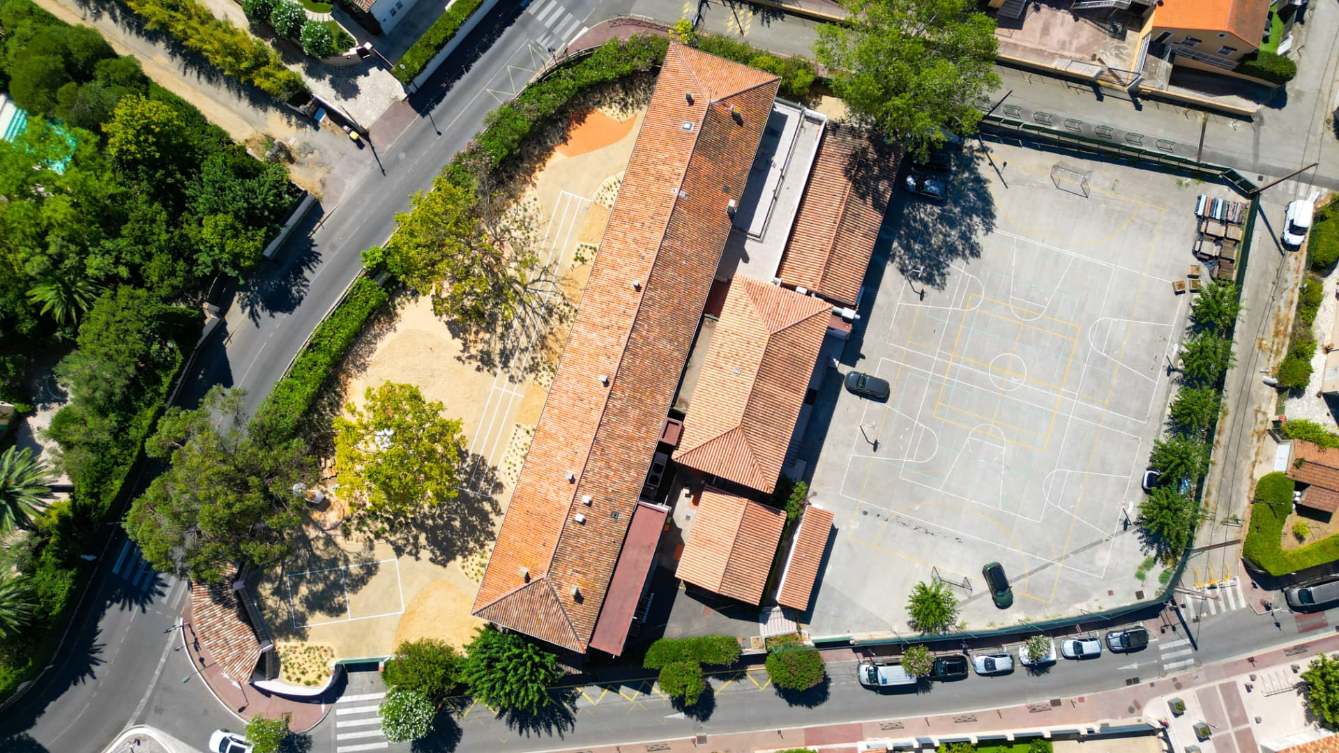 Vue verticale au drone d'un groupe scolaire, de sa cour et de son terrain de sport